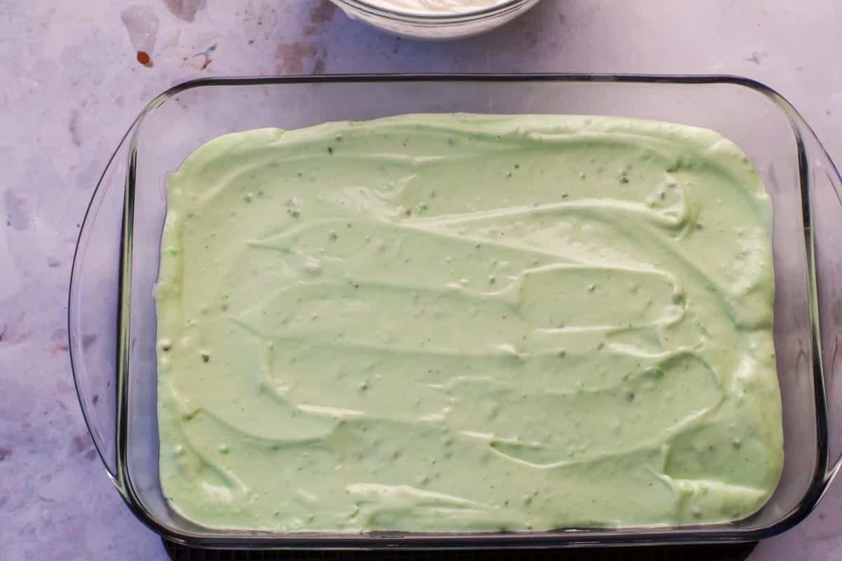 Pistachio pudding ice cream mixture spread over cooled chocolate base in 9x13 glass pan.