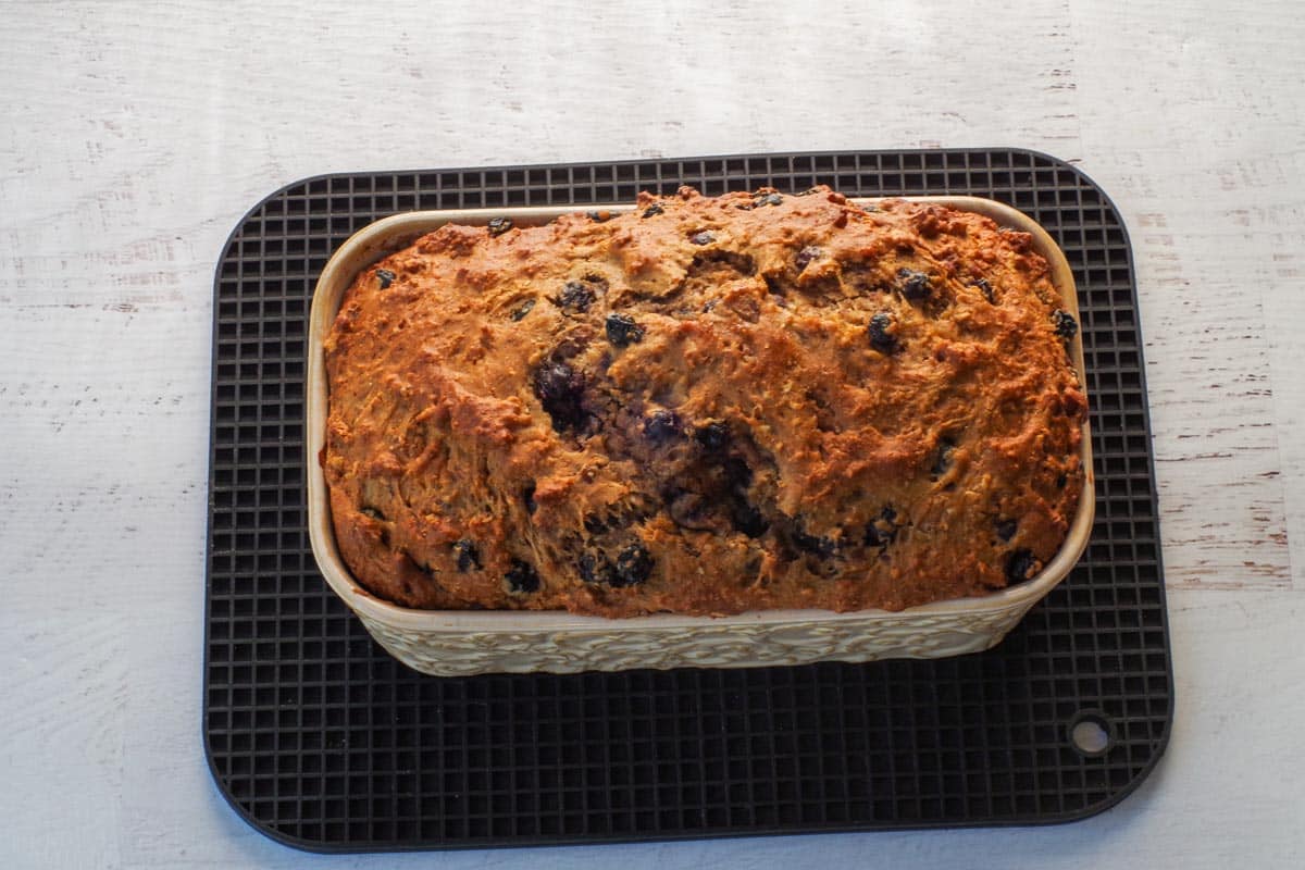  Baked Saskatoon Berry Loaf in pan on black trivet.
