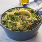 Lazy Greek Dolmades in a blue casserole dish with a spoon in it.