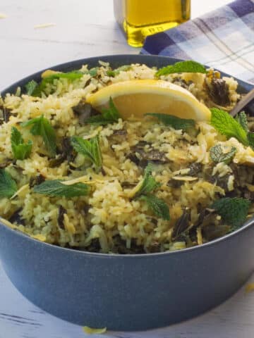 Lazy Greek Dolmades in a blue casserole dish with a spoon in it.