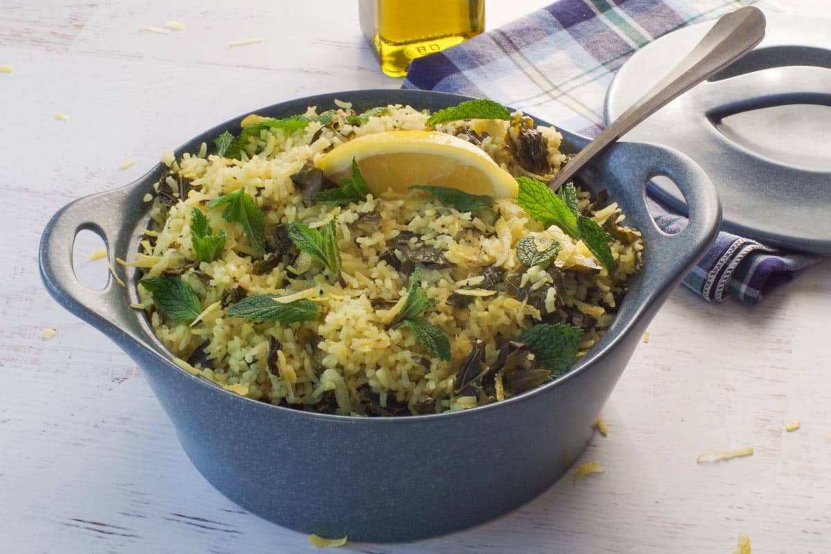 Lazy Greek Dolmades in a blue casserole dish with a spoon in it.