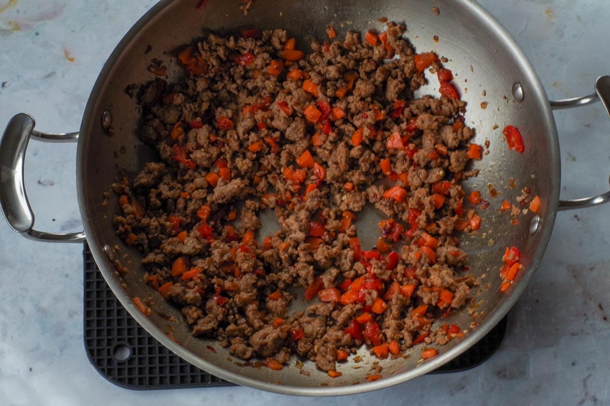 Thai chili paste added to the chicken veggie mixture in wok.