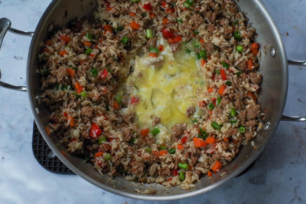 Eggs scrambled little in the middle of the wok.