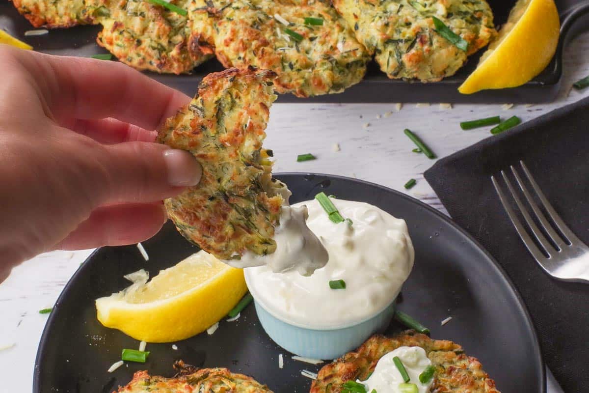 Air Fryer Zucchini Fritter being dipped into tzatziki.