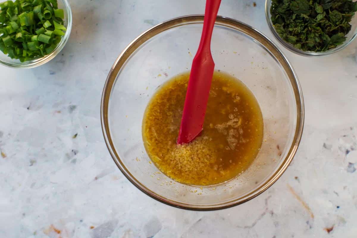 Bulgur in a small bowl with lemon juice mixture poured over it.