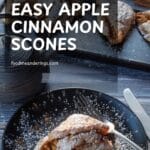 Apple Cinnamon Scone on black plate with a tray of more scones in the background.