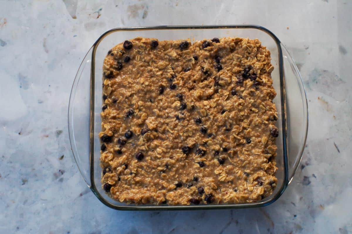 Batter for Saaskatoon Berry Oatmeal Bars poured into prepared 8x8 bars.