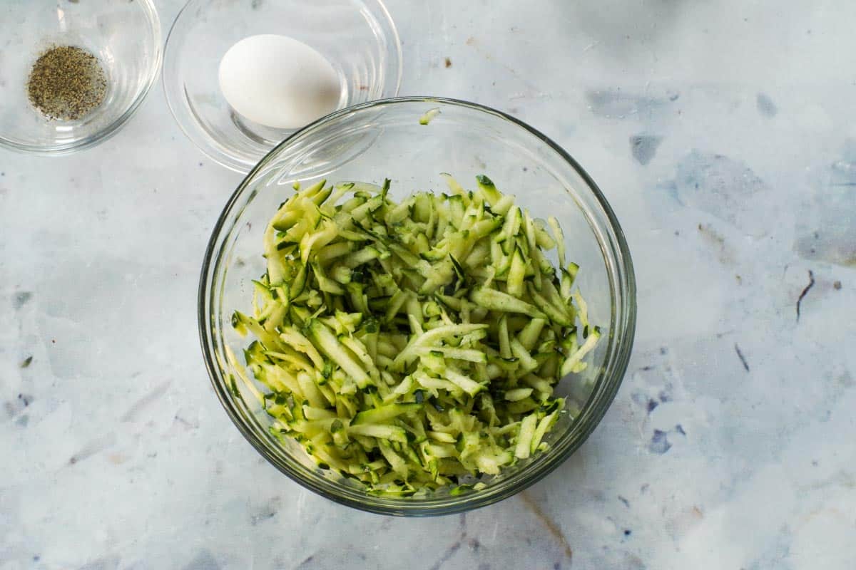 Salted zucchini sitting in a glass bowl.