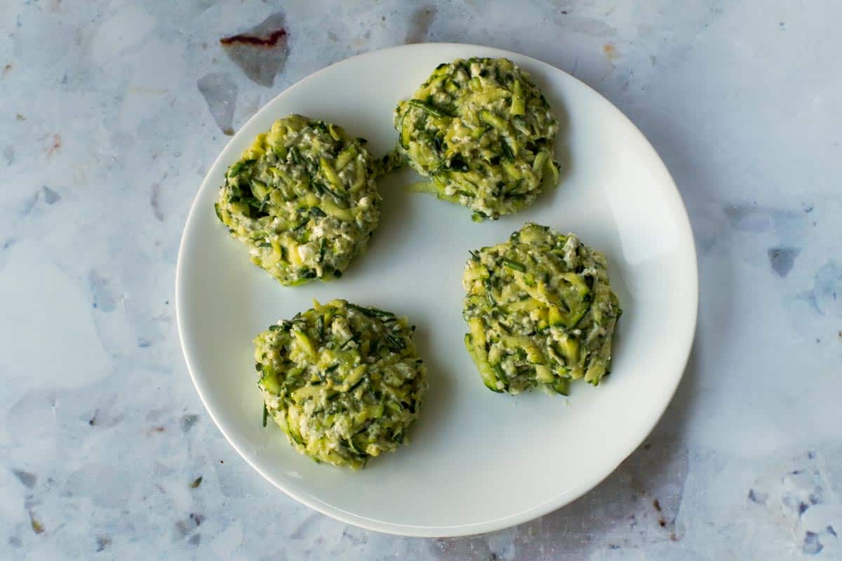 Zucchini fritter mixture formed into 4 small patties.