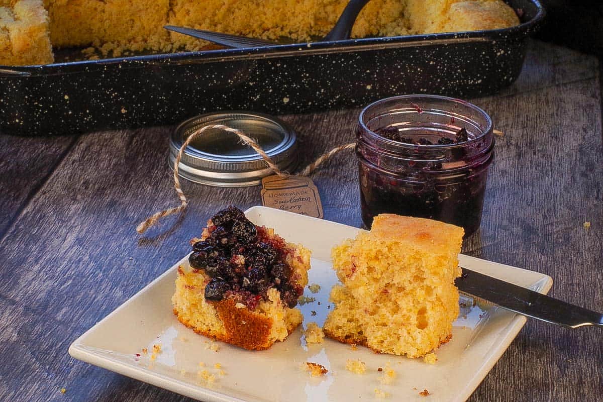 Cornbread without buttermilk on a white plate with jam.