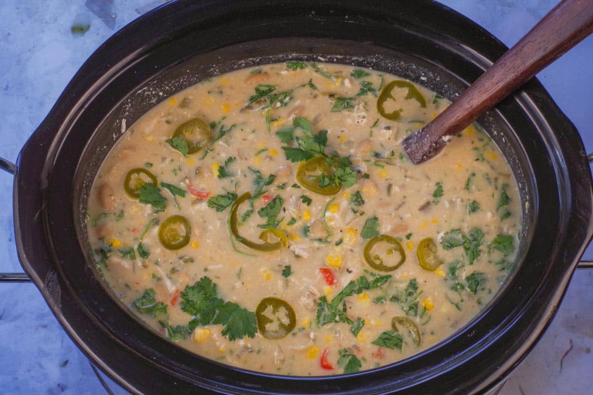 Lime juice, fresh cilantro and tamed jalapenos added to white chicken chili in crockpot.