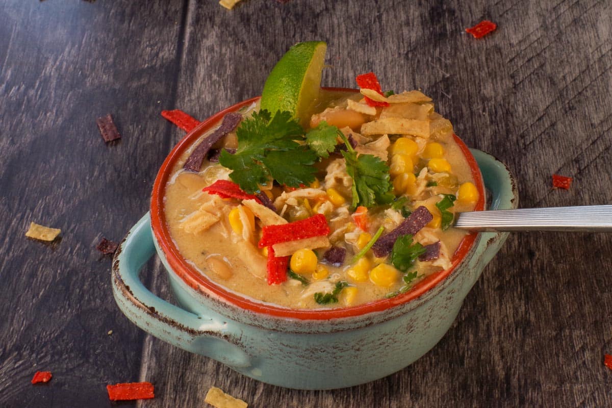 A bowl of Healthy Crockpot White Chicken Chili with a spoon in it.