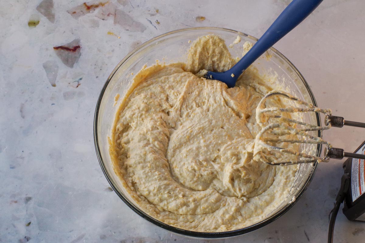 Wet and dry ingredients combined in large glass bowl.