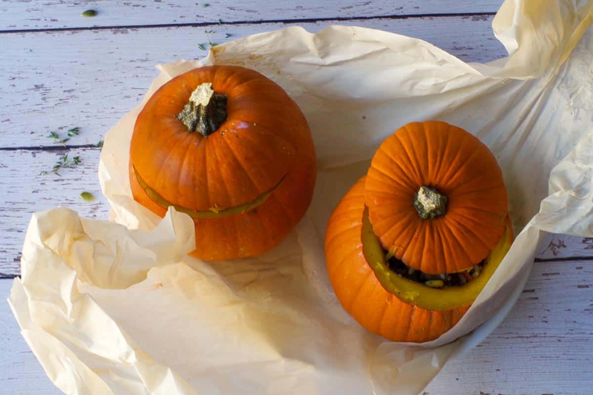 Pumpkins lifted out of slow cooker and onto a platter with parchment sling.