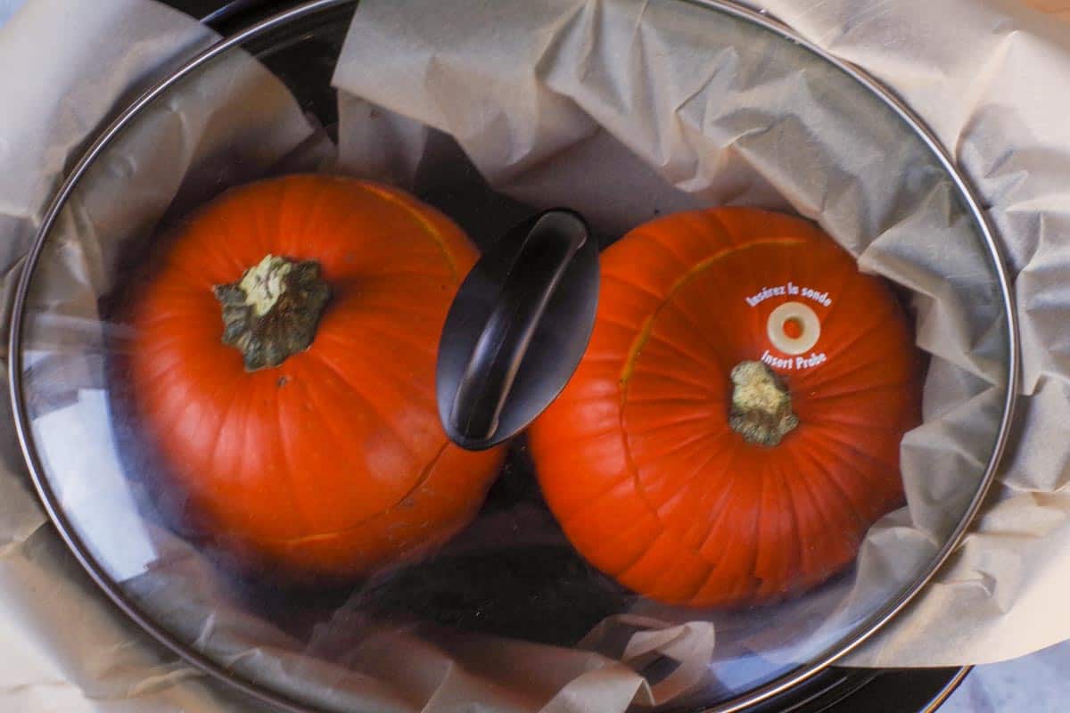 Pumpkins in slow cooker covered with lid.